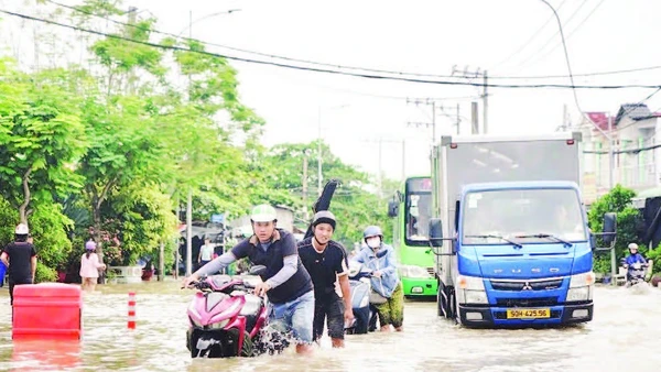 Triều cường gây ngập nặng tuyến đường Đào Sư Tích, xã Nhà Bè, làm đảo lộn cuộc sống của người dân. (Ảnh THẾ ANH)