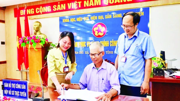 Cán bộ Trung tâm Phục vụ hành chính công xã Tam Nông hỗ trợ người dân thực hiện các thủ tục hành chính.