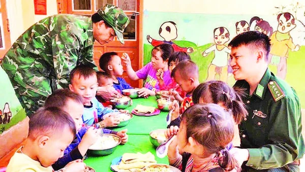 Thiếu tá Cầm Bá Thành (bên phải ảnh) cùng với đồng đội thực hiện “Bữa sáng cho em” tại điểm Trường mầm non Buốc Pát.