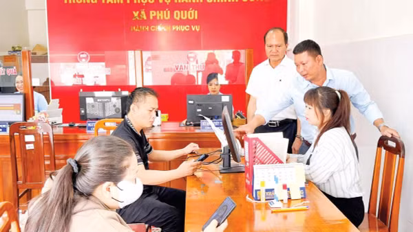 Cán bộ Trung tâm Phục vụ hành chính công xã Phú Quới hướng dẫn người dân làm thủ tục hành chính. 