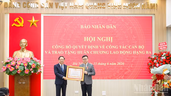 Đồng chí Trịnh Văn Quyết, Ủy viên Bộ Chính trị, Bí thư Trung ương Đảng, Trưởng ban Tuyên giáo và Dân vận Trung ương trao Huân chương Lao động hạng Ba cho Tổng Biên tập Báo Nhân Dân Lê Quốc Minh.