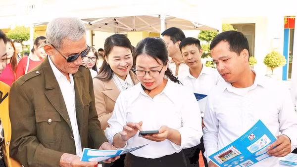 Cán bộ phường An Phong hướng dẫn người dân lấy số thứ tự giải quyết thủ tục hành chính trên VNeID.