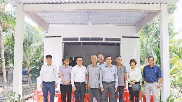 Lãnh đạo Báo Nhân Dân chụp ảnh lưu niệm trong một lần tặng quà hỗ trợ xây dựng nhà “Đại đoàn kết” khu vực Đồng bằng sông Cửu Long. Ảnh: BÁ DŨNG