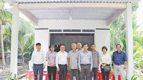 Lãnh đạo Báo Nhân Dân chụp ảnh lưu niệm trong một lần tặng quà hỗ trợ xây dựng nhà “Đại đoàn kết” khu vực Đồng bằng sông Cửu Long. Ảnh: BÁ DŨNG