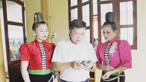 Cán bộ phường Chiềng Cơi hướng dẫn người dân cài đặt và sử dụng ứng dụng số trên điện thoại. Ảnh: BSL