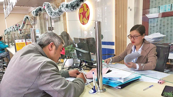 Cán bộ Trung tâm phục vụ hành chính công phường Lang Biang - Đà Lạt làm thủ tục hành chính phục vụ người dân.