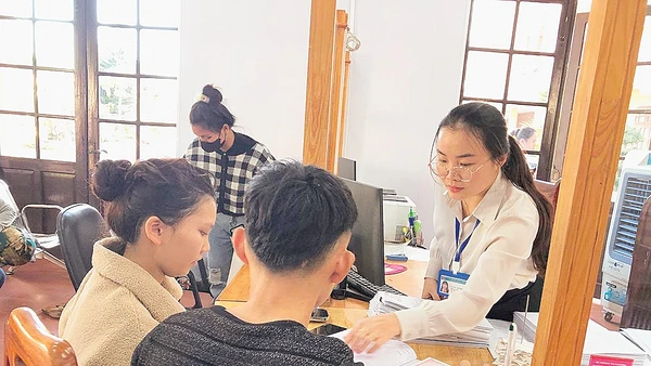 Cán bộ Trung tâm Phục vụ hành chính công xã Đức Trọng trả kết quả giải quyết thủ tục hành chính cho người dân.