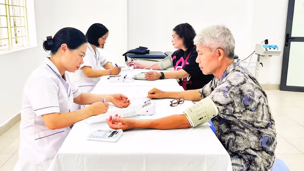 Các bác sĩ, nhân viên y tế Trạm Y tế phường Khương Đình khám sức khỏe định kỳ cho người dân trên địa bàn.