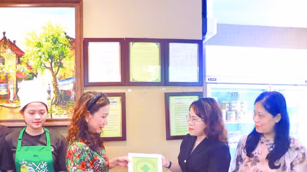 Đại diện UBND phường Cửa Nam trao Giấy chứng nhận đủ điều kiện an toàn thực phẩm cho cơ sở trên phố Quang Trung.
