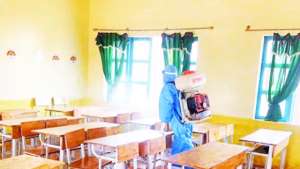 Cán bộ Trung tâm Y tế Krông Búk phun hóa chất xử lý ổ dịch quai bị tại trường học xã Cư Pơng (Ảnh MAI LÊ)