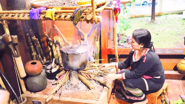 Người phụ nữ Ê Đê bên bếp lửa ở gian cuối ngôi nhà dài trong giờ nấu ăn cho gia đình.