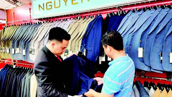 Cơ sở sản xuất Nguyễn Trung của làng nghề may Vân Từ giới thiệu sản phẩm tới khách hàng.