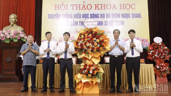 Các đại biểu tặng hoa chúc mừng Hội thảo. (Ảnh: A.T)