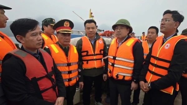 Chủ tịch Ủy ban nhân dân tỉnh Lào Cai Nguyễn Tuấn Anh (người đội mũ, thứ ba từ phải sang) trực tiếp có mặt tại hiện trường, chỉ đạo công tác cứu hộ các nạn nhân bị chìm tàu trên hồ Thác Bà tối 21/2.