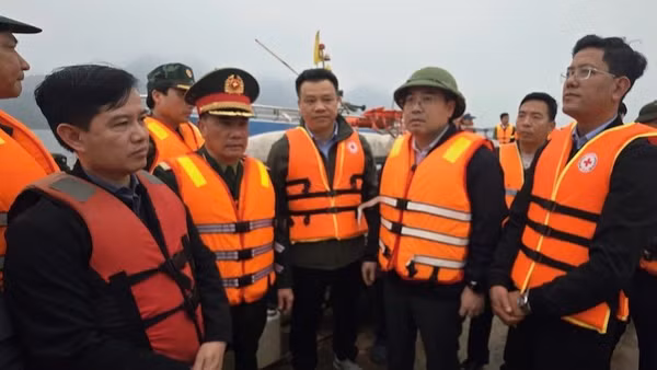 Chủ tịch Ủy ban nhân dân tỉnh Lào Cai Nguyễn Tuấn Anh (người đội mũ, thứ ba từ phải sang) trực tiếp có mặt tại hiện trường, chỉ đạo công tác cứu hộ các nạn nhân bị chìm tàu trên hồ Thác Bà tối 21/2.