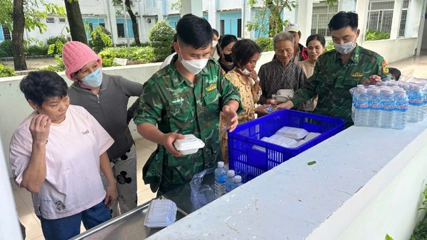 Cán bộ, chiến sĩ Đồn Biên phòng Xuân Đài phát những hộp cơm và chai nước uống 0 đồng cho người dân vùng thiên tai.