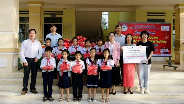 Đại diện Sở Giáo dục và Đào tạo tỉnh Đắk Lắk cùng nhà tài trợ trao tặng những phần quà Tết đến các em học sinh. (Ảnh: PV)