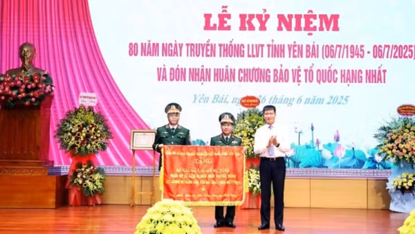 Đồng chí Bí thư Tỉnh ủy Yên Bái Trần Huy Tuấn trao cờ thêu cho Lực lượng vũ trang tỉnh. 