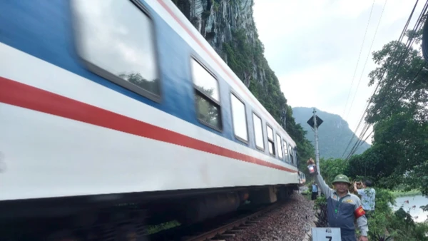 Nhân viên tuần hầm hướng dẫn tàu qua an toàn trên đoạn đường sắt xung yếu bên sông, bên núi đá ở huyện Tuyên Hóa, tỉnh Quảng Bình.