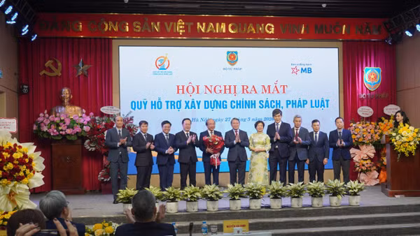 Bộ trưởng Tư pháp Nguyễn Hải Ninh tặng hoa và chúc mừng các thành viên Hội đồng quản lý Quỹ hỗ trợ xây dựng chính sách, pháp luật.