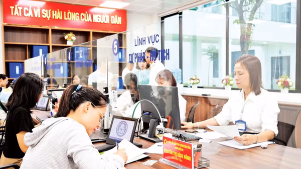 Người dân làm việc với cán bộ tiếp nhận tại bộ phận một cửa phường Đống Đa, Hà Nội. (Ảnh: THẾ ĐẠI)