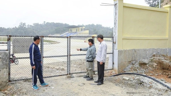 Ông Lò Văn Khăm (bên trái) cùng người dân trong bản Pú Tỉu 2 (phường Mường Thanh), chỉ cho phóng viên dấu tích con đường cũ về bản hiện là một góc trong sân vận động mới được đầu tư xây dựng hiện đại. 