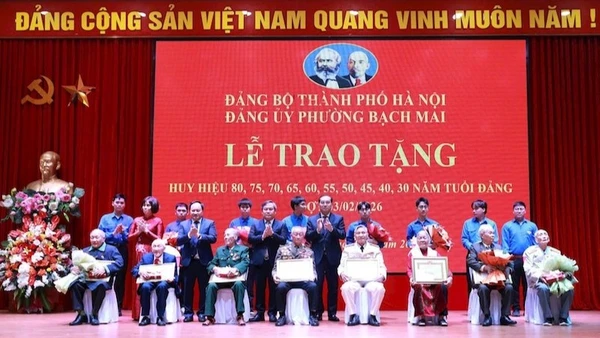 Đồng chí Chủ tịch Ủy ban nhân dân thành phố Hà Nội Vũ Đại Thắng và các đồng chí lãnh đạo phường Bạch Mai trao huy hiệu 80 năm, 75 năm, 70 năm tuổi Đảng tặng các đảng viên. (Ảnh: Đình Hiệp)