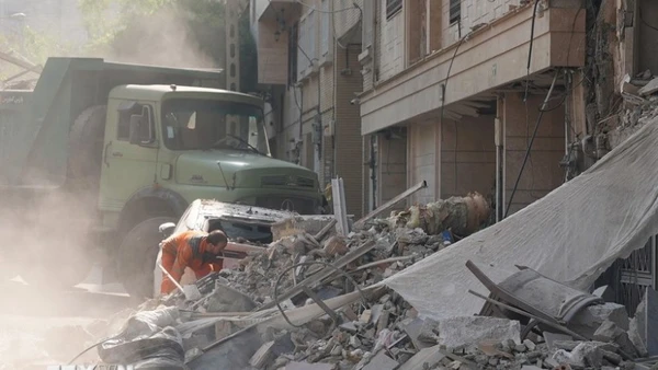 Nhân viên cứu hộ dọn đống đổ nát của tòa nhà bị sập tại Tehran, Iran sau các cuộc không kích của Israel. (Ảnh: THX/TTXVN)