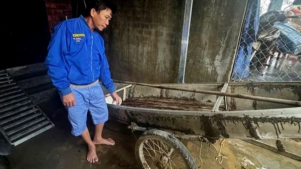 Ông Trần Công Thành bên chiếc ghe nhỏ dùng để cứu người trong lũ dữ.