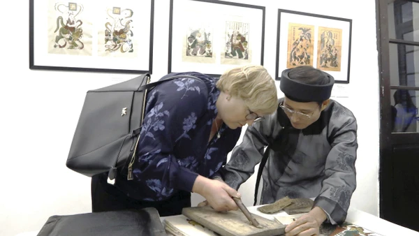 Nghệ nhân Nguyễn Hữu Quả giới thiệu kỹ thuật in tranh Đông Hồ tới du khách quốc tế, tại Bảo tàng Mỹ thuật Việt Nam.