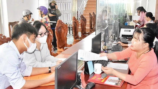Cán bộ Trung tâm Phục vụ hành chính công phường Mỹ Phong hướng dẫn người dân đến làm thủ tục hành chính. 
