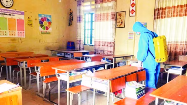 Thực hiện phun khử khuẩn tại trường học có học sinh mắc bệnh. (Ảnh PHƯƠNG THẢO)