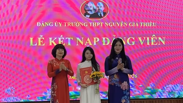 Bí thư Đảng ủy, Chủ tịch Hội đồng nhân dân phường Bồ Đề Vũ Thị Thành (người đứng bên trái) trao quyết định kết nạp Đảng cho học sinh trường Trung học phổ thông Nguyễn Gia Thiều.