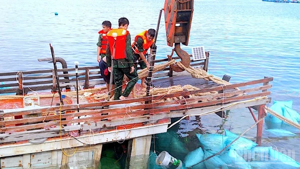 Cán bộ, chiến sĩ Đồn Biên phòng Hòn Chuối hỗ trợ trục vớt tàu cá gặp nạn trên vùng biển Cà Mau. 