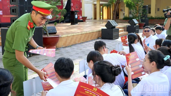 Cán bộ Công an tỉnh Cà Mau phát tờ rơi tuyên truyền nâng cao nhận thức pháp luật trên không gian mạng cho học sinh Trường trung học phổ thông chuyên Phan Ngọc Hiển.