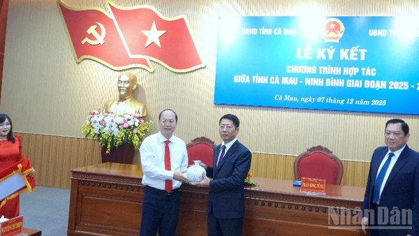 Bí thư Tỉnh ủy Cà Mau Nguyễn Hồ Hải (bìa trái) tặng quà lưu niệm cho đại diện tỉnh Ninh Bình tại lễ ký kết.