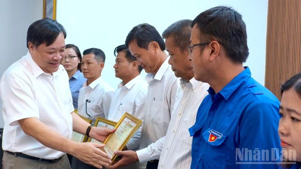 Chủ tịch Ủy ban nhân dân tỉnh Cà Mau Phạm Thành Ngại (bìa trái) tặng Bằng khen cho các cá nhân có nhiều đóng góp trong phong trào xóa nhà tạm, nhà dột nát.