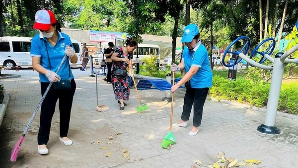 Người dân tham gia dọn dẹp vườn hoa Trần Quang Diệu sau một thời gian bị xuống cấp. 