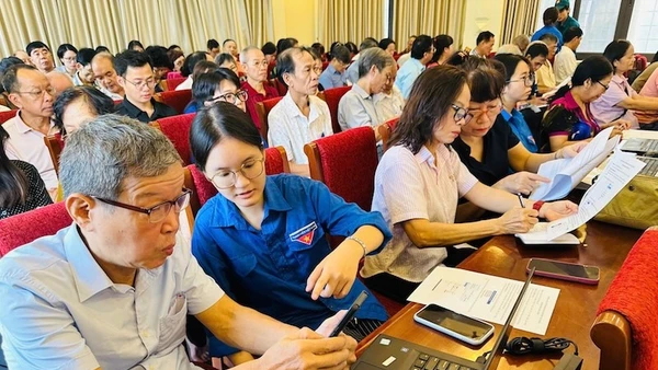Đoàn viên thanh niên phường Văn Miếu-Quốc Tử Giám hỗ trợ các đảng viên thực hiện các thủ tục hành chính của Đảng trên Cổng dịch vụ công quốc gia. (Ảnh: BẢO LÂM). 