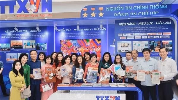 Cán bộ, phóng viên giới thiệu các sản phẩm thông tin chủ lực của TTXVN trưng bày tại Hội báo toàn quốc.