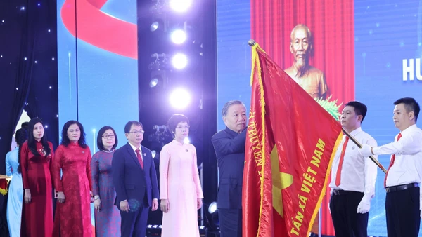 Tổng Bí thư Tô Lâm gắn Huân chương Hồ Chí Minh lên lá cờ truyền thống Thông tấn xã Việt Nam. Ảnh: Lâm Khánh - TTXVN