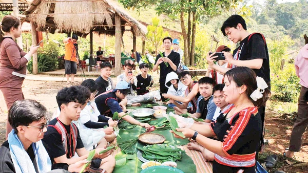 Hướng dẫn du khách trải nghiệm gói bánh dân tộc.