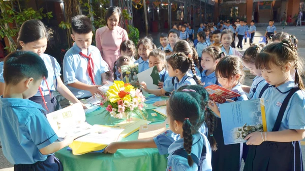 Học sinh Trường Tiểu học Kim Đồng, phường Rạch Giá tham khảo sách hướng dẫn sưu tập tem.