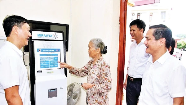 Cán bộ xã Đại Đồng hướng dẫn người dân làm thủ tục hành chính trên máy.