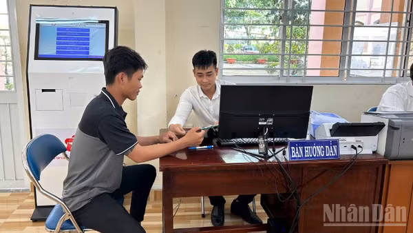 Cán bộ Trung tâm Phục vụ hành chính công xã Mỹ Lợi hướng dẫn người dân thao tác nộp hồ sơ trực tuyến. 