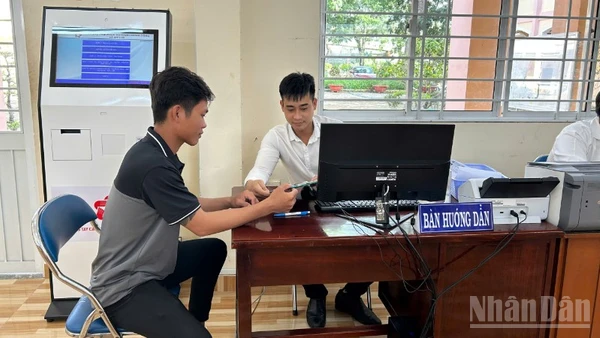 Cán bộ Trung tâm Phục vụ hành chính công xã Mỹ Lợi hướng dẫn người dân thao tác nộp hồ sơ trực tuyến. 