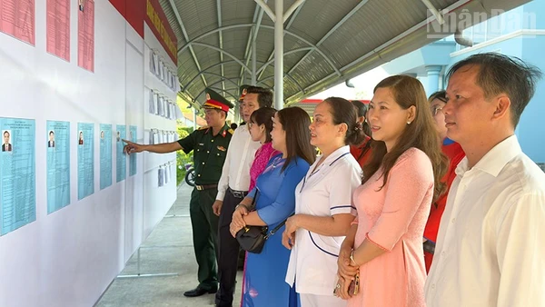 Cán bộ và người dân xem danh sách ứng cử. 