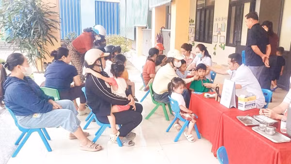 Người dân đưa trẻ đến tiêm chủng vắc-xin tại Trạm Y tế xã Hương Phố, tỉnh Hà Tĩnh.