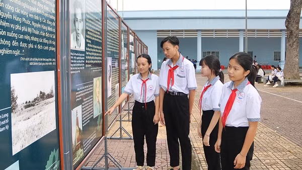 Học sinh xã Trung Thành, tỉnh Vĩnh Long xem triển lãm ảnh với chủ đề kỷ niệm 85 năm Ngày Khởi nghĩa Nam Kỳ.