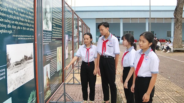 Học sinh xã Trung Thành, tỉnh Vĩnh Long xem triển lãm ảnh với chủ đề kỷ niệm 85 năm Ngày Khởi nghĩa Nam Kỳ.